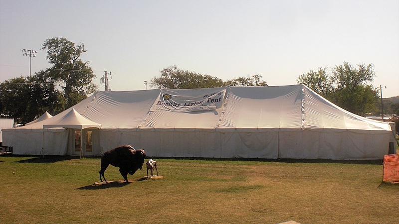 Extra long white tent at a fair grounds.
