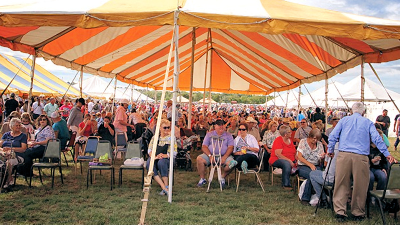 Interior of a tent filled with people for a revival.
